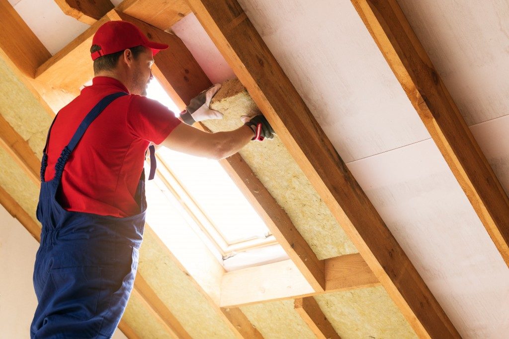 House attic insulation being installed by worker