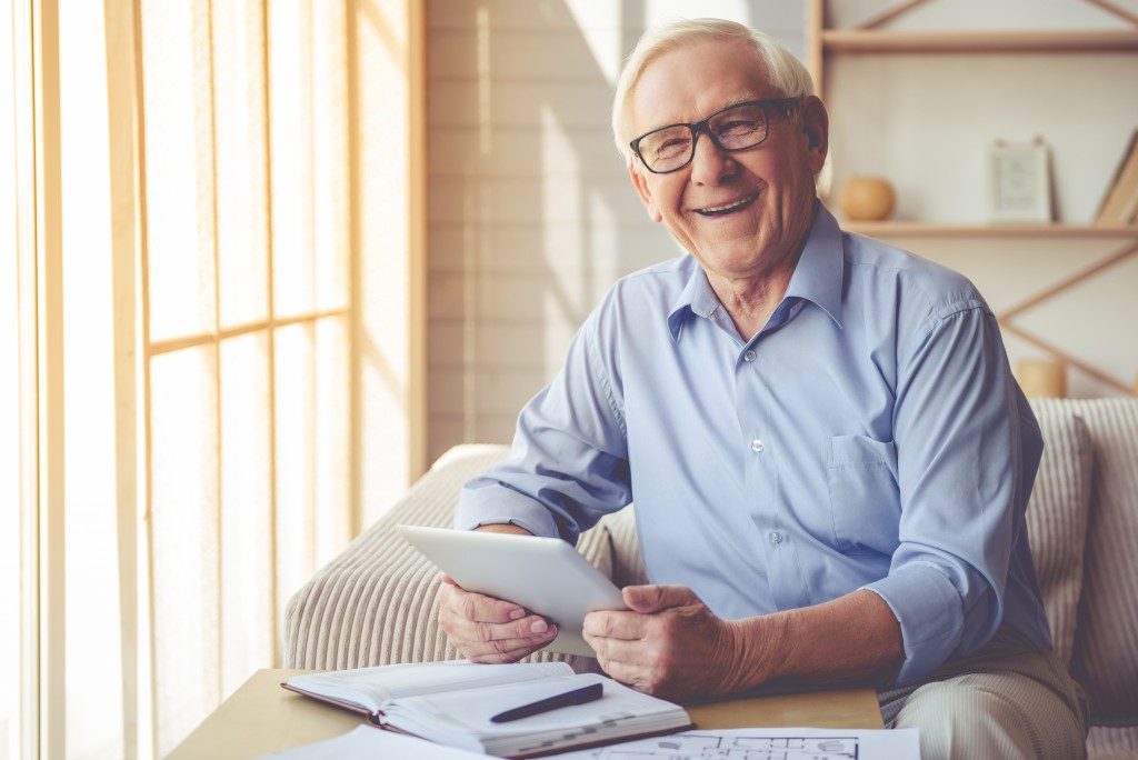 Elderly man holding a tablet