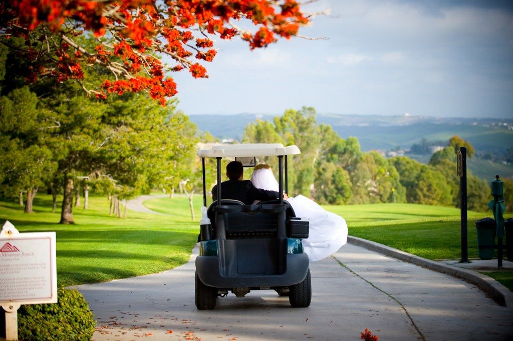 newlyweds riding a golf cart