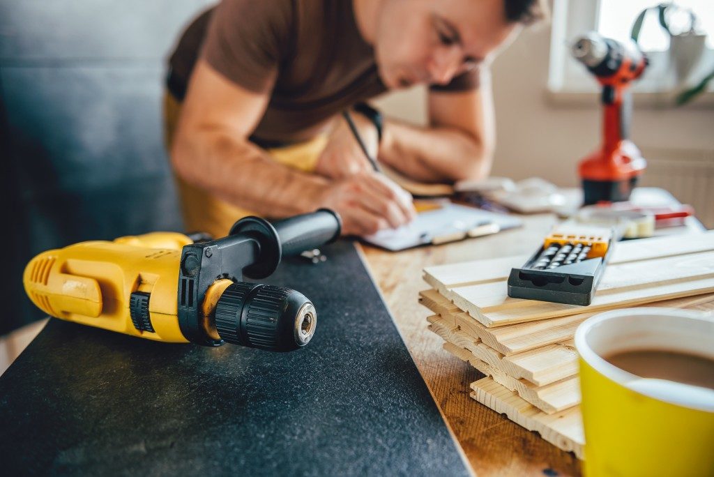 man planning construction and renovation plans with tools and wood on the table