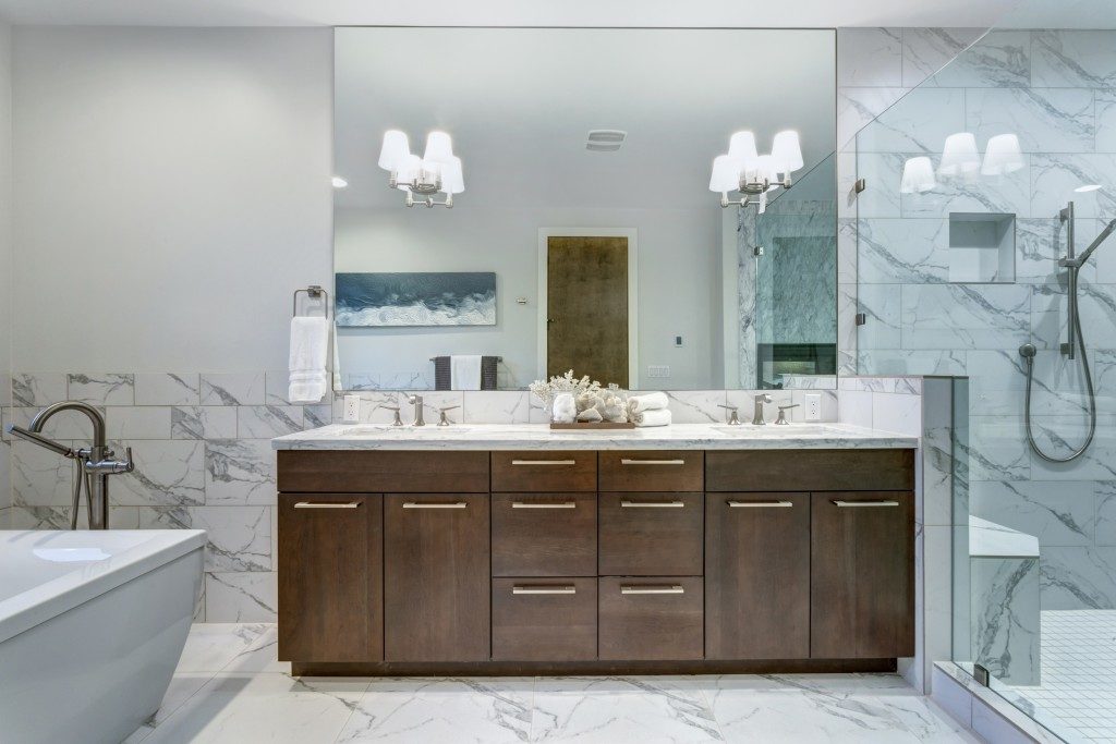 Bathroom with white marble tiles and big vanity sink and mirror