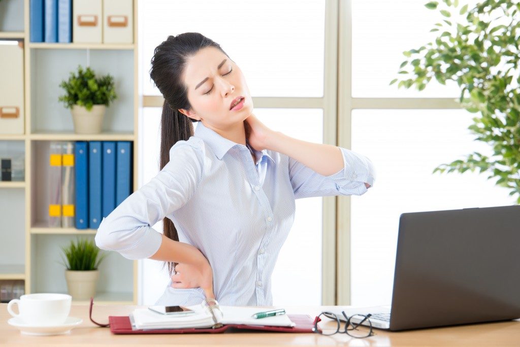 woman working experiencing back pain