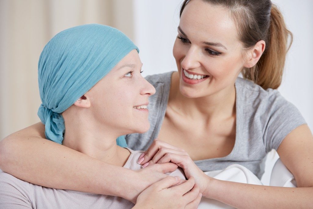 Mother hugging daughter with cancer