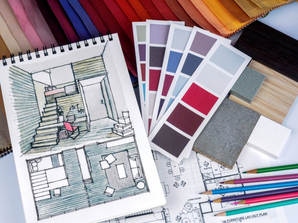 sketch of house remodel, swatches of color, blueprint and color pencils